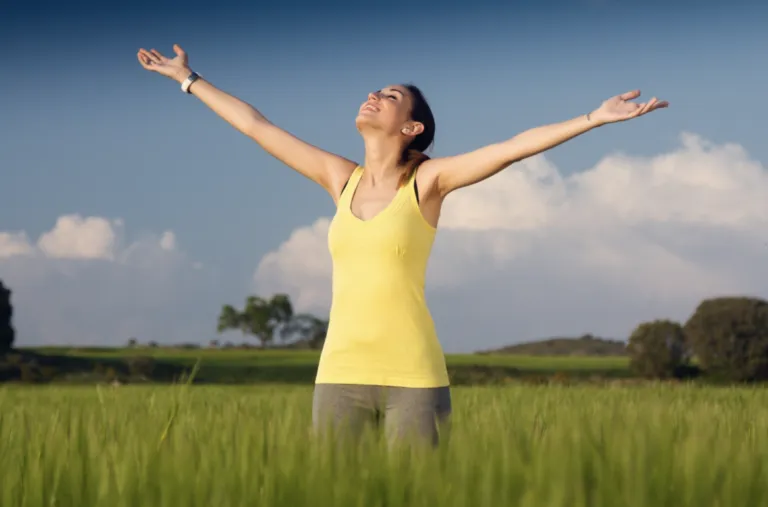 Mujer luego de hidratarse con Agua VIDA con Vitaminas Antioxidantes en un entorno luminoso y saludable.
