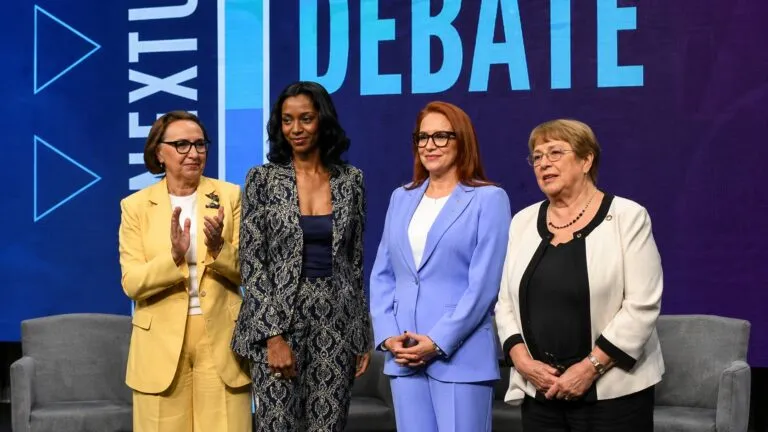 Tres mujeres participan en un evento público sobre liderazgo internacional y representación femenina en organismos globales. Mujer - ONU