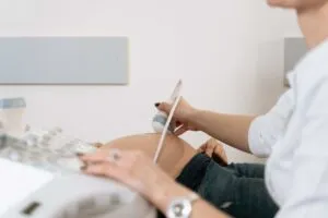 Especialista realiza un ultrasonido prenatal a una mujer embarazada durante una consulta de medicina materno fetal.