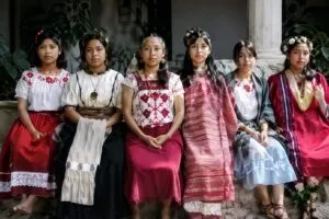Violinistas indígenas de Oaxaca interpretan música tradicional en una representación editorial inspirada en el encuentro cultural de Bellas Artes.
