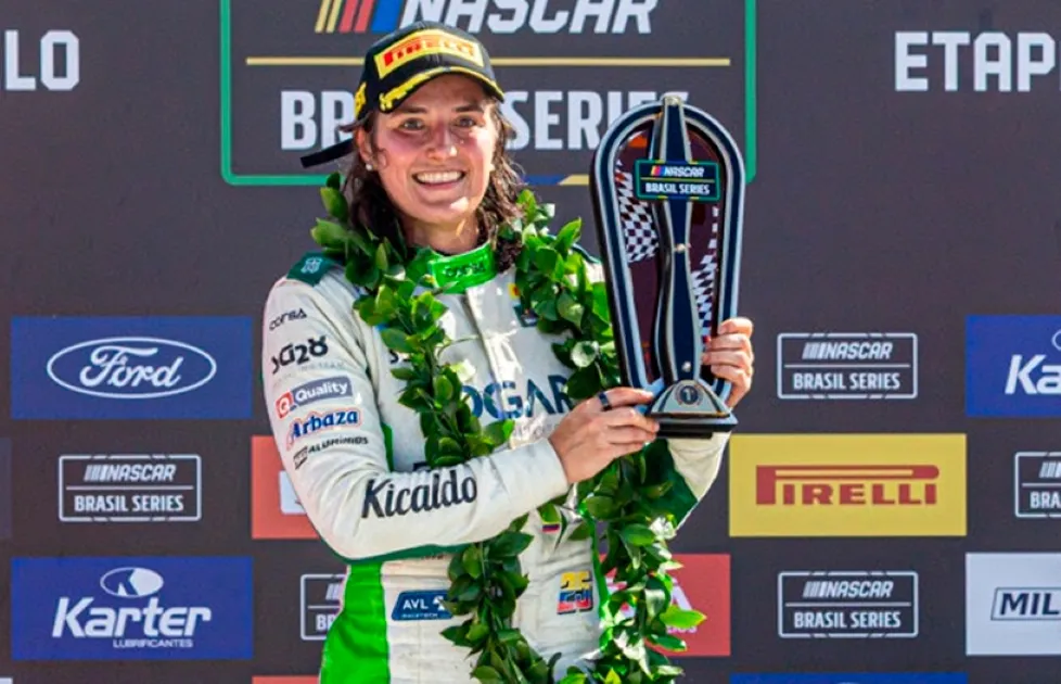 Ilustración de una piloto junto a un auto de carreras en Brasil, alusiva a la victoria de Tatiana Calderón en NASCAR Brasil.