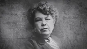 Médica con bata blanca junto a un libro antiguo de medicina, en representación del legado de Consuelo Gutiérrez García en Guanajuato.