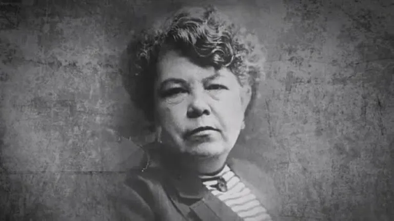 Médica con bata blanca junto a un libro antiguo de medicina, en representación del legado de Consuelo Gutiérrez García en Guanajuato.